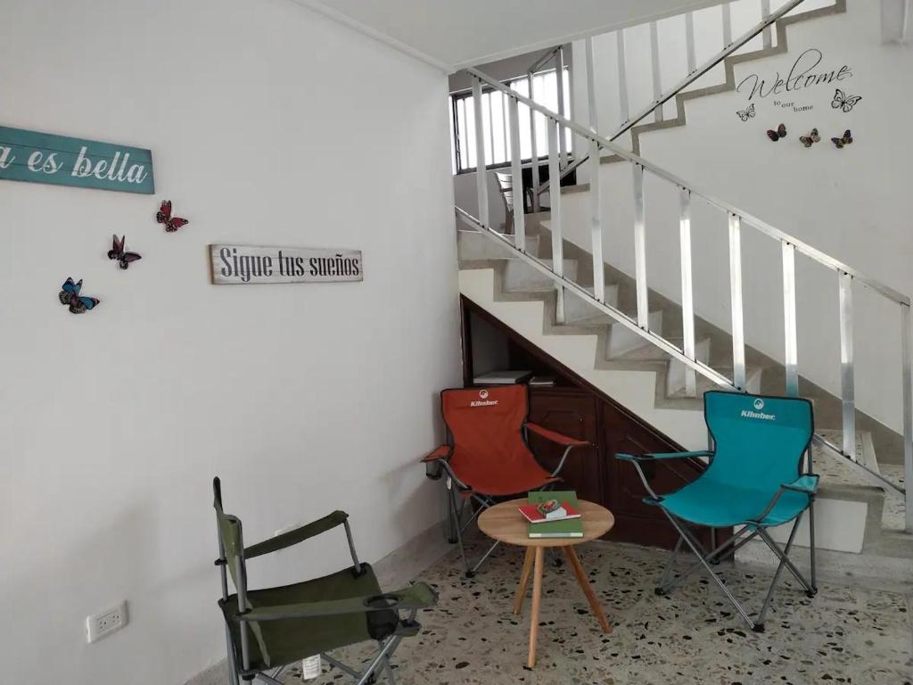 麦德林Casa Nogal 76的楼梯旁的三把椅子和一张桌子
