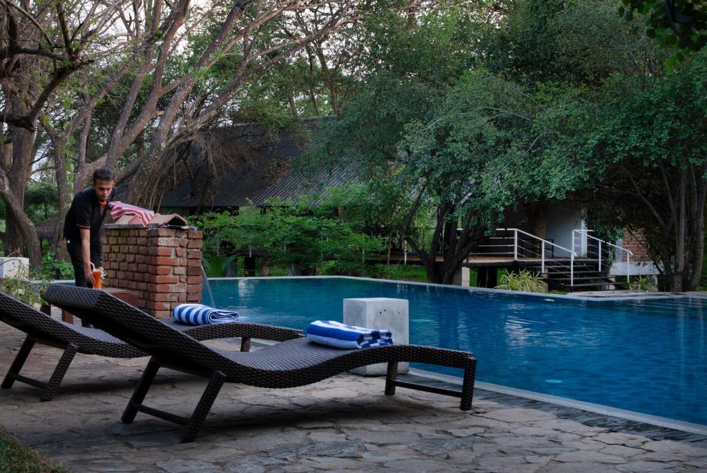 锡吉里亚Lario Resort Sigiriya的站在游泳池旁的人
