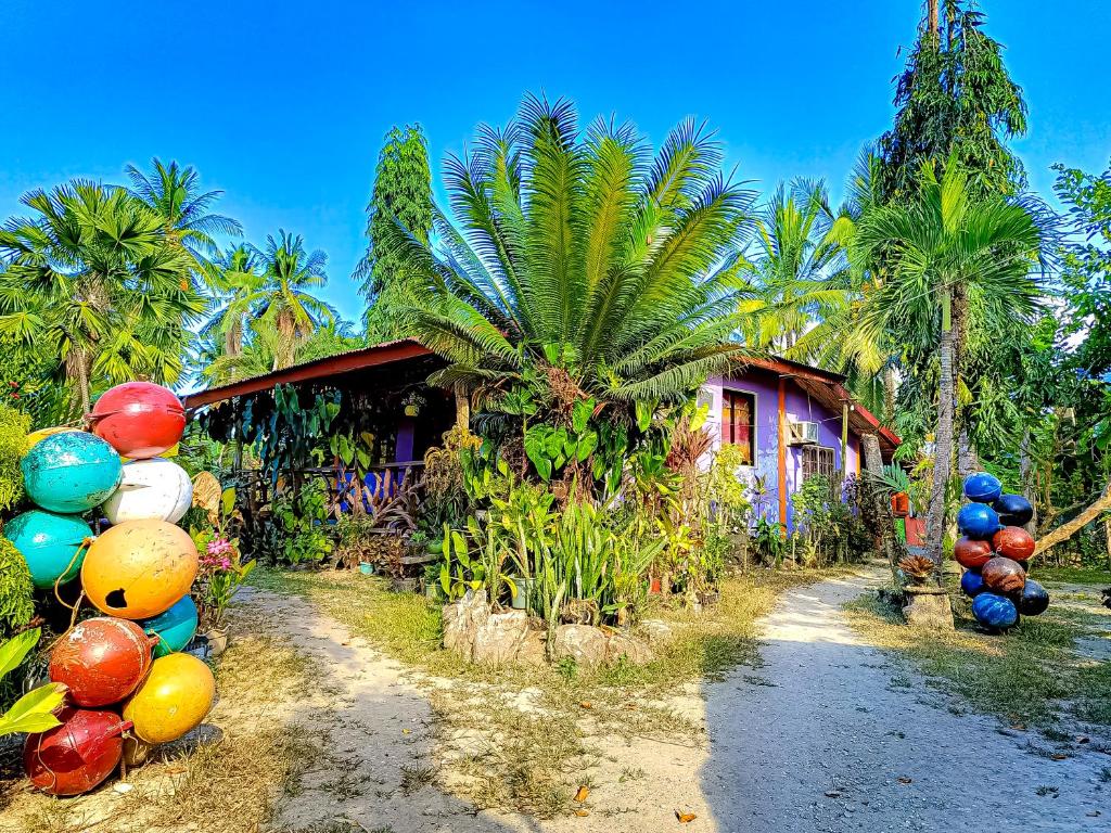 InandengA. Zaragosa Lodging House的棕榈树和五颜六色的气球的房子