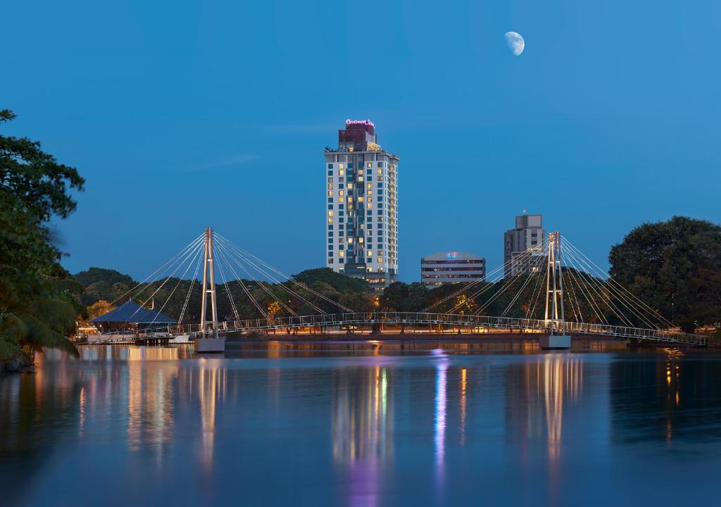 科伦坡科伦坡肉桂红酒店的一座河上的桥梁,以城市为背景