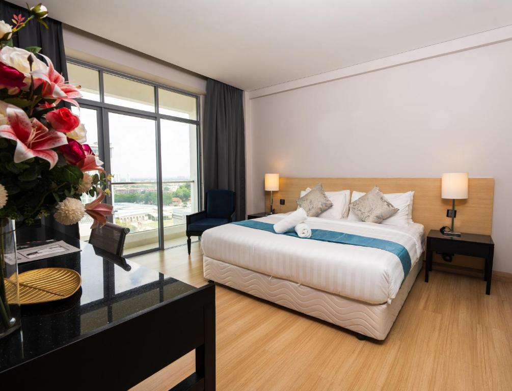 马六甲The Straits Melaka by Perfect Host的酒店客房设有一张床和一个大窗户