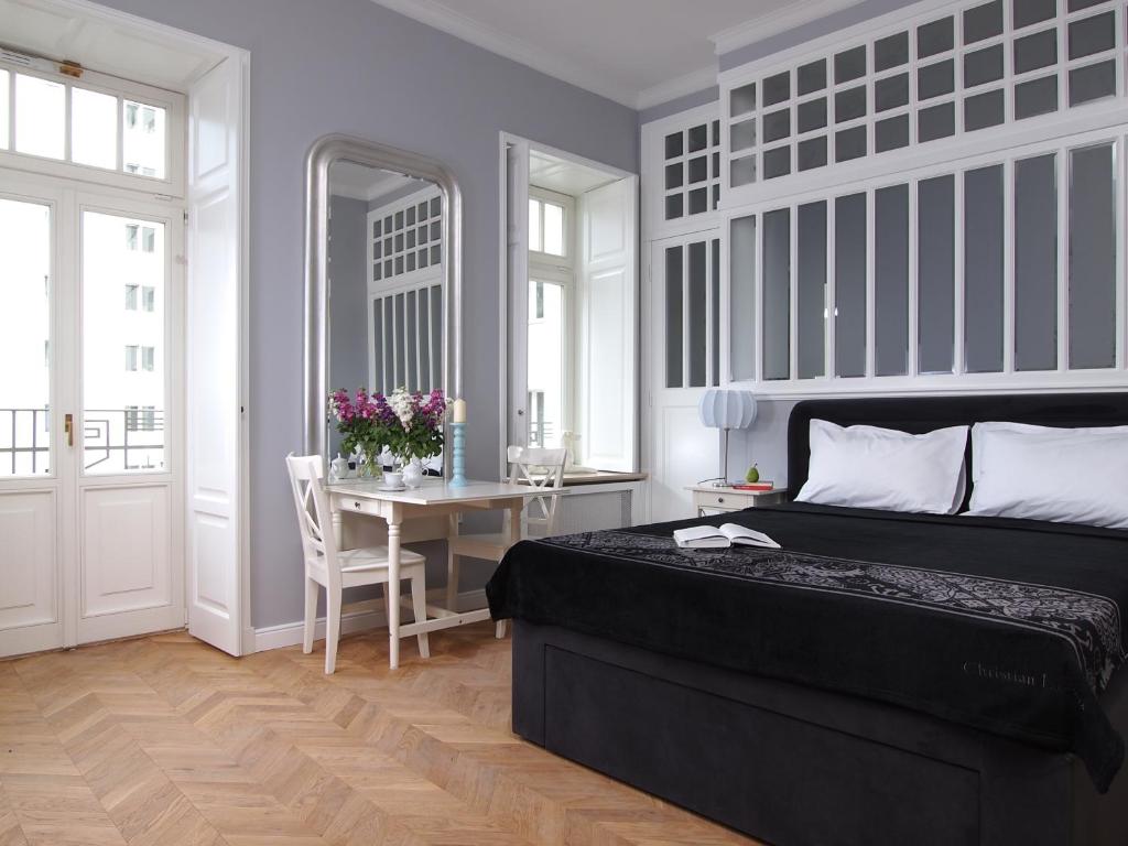 华沙华沙概念公寓的一间卧室配有一张黑色的床和一张桌子及一张桌子