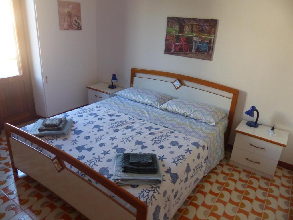 圣维托罗卡波Villetta Fiorita的一间卧室配有一张带蓝色和白色棉被的床
