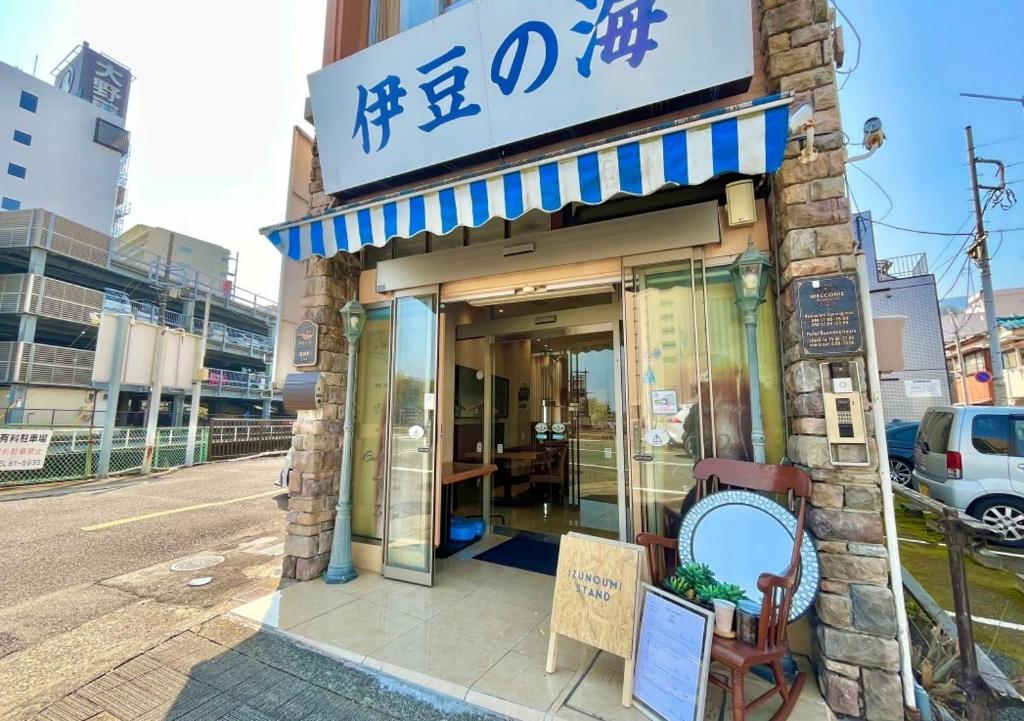 热海Hostel and Cafe izu-no-umi的街道边有标志的建筑物