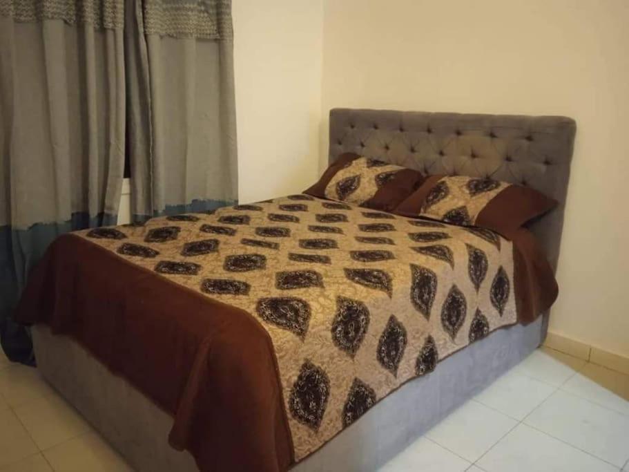 Tujering3 bedroom, free Wi-fi, Aircon & Hot water的一间卧室配有一张带被子和枕头的床
