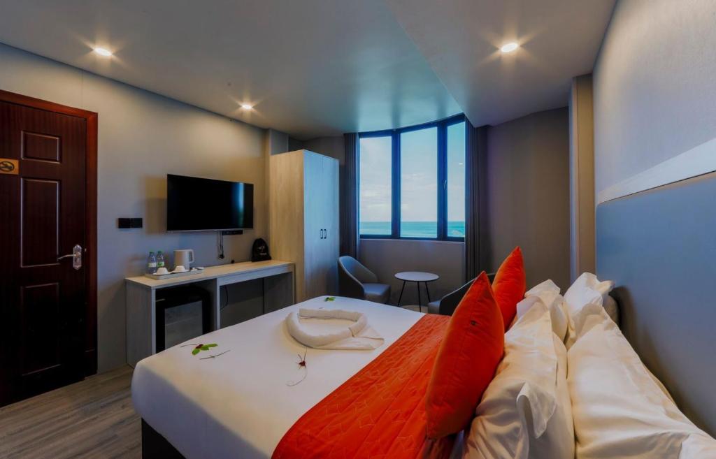 胡鲁马累Starry Beach Inn的酒店客房配有一张带红色枕头的大床