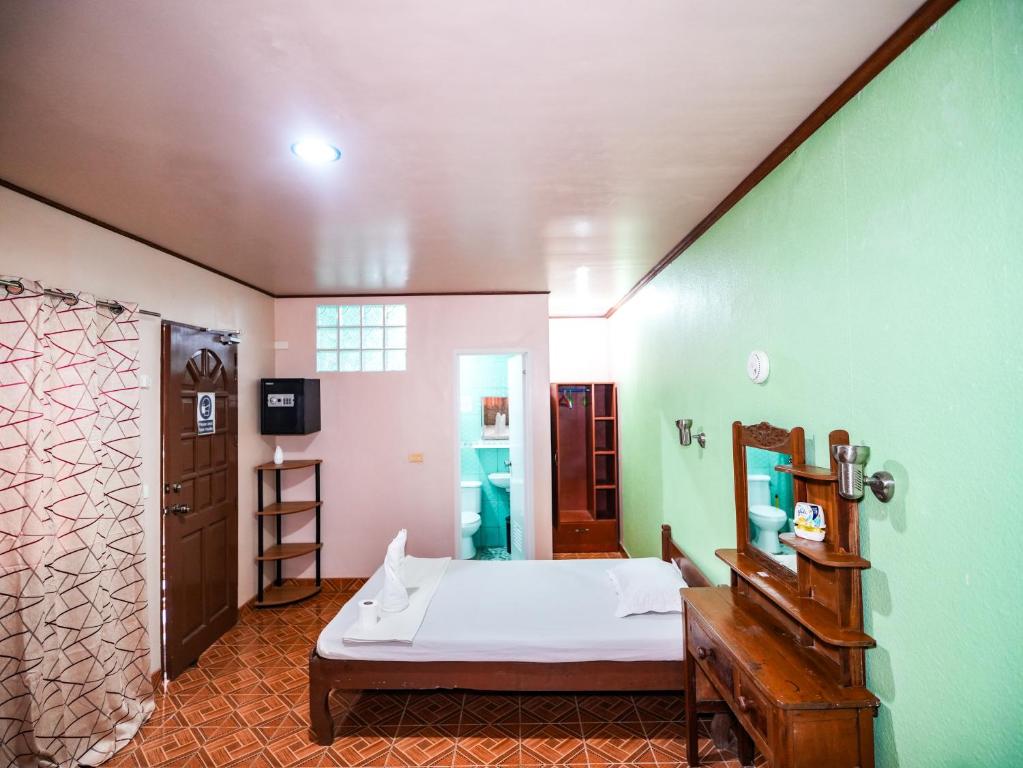 长滩岛Gracias Inn的一间卧室设有一张床和绿色的墙壁