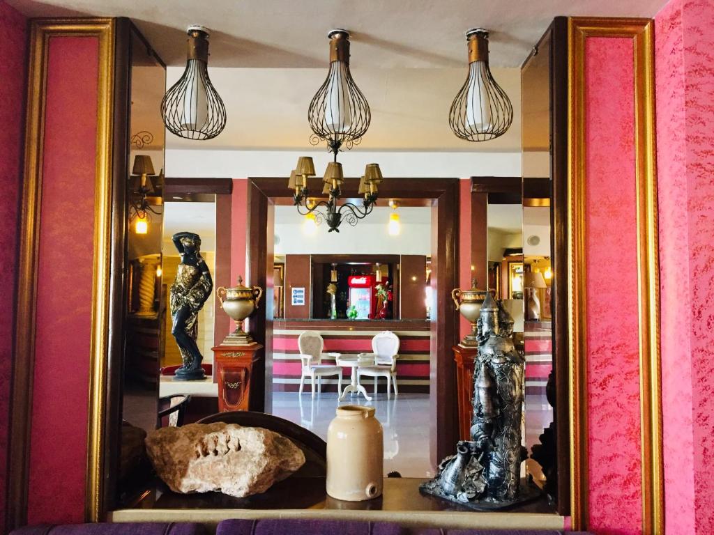 奥兰Hotel Les Ambassadeurs的带用餐室的客房内的镜子