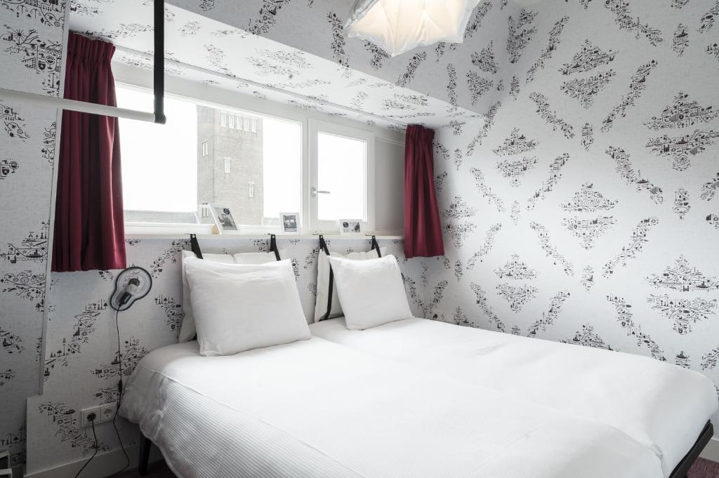 马斯特里赫特KABOOM Maastricht的卧室配有白色的床和红色窗帘
