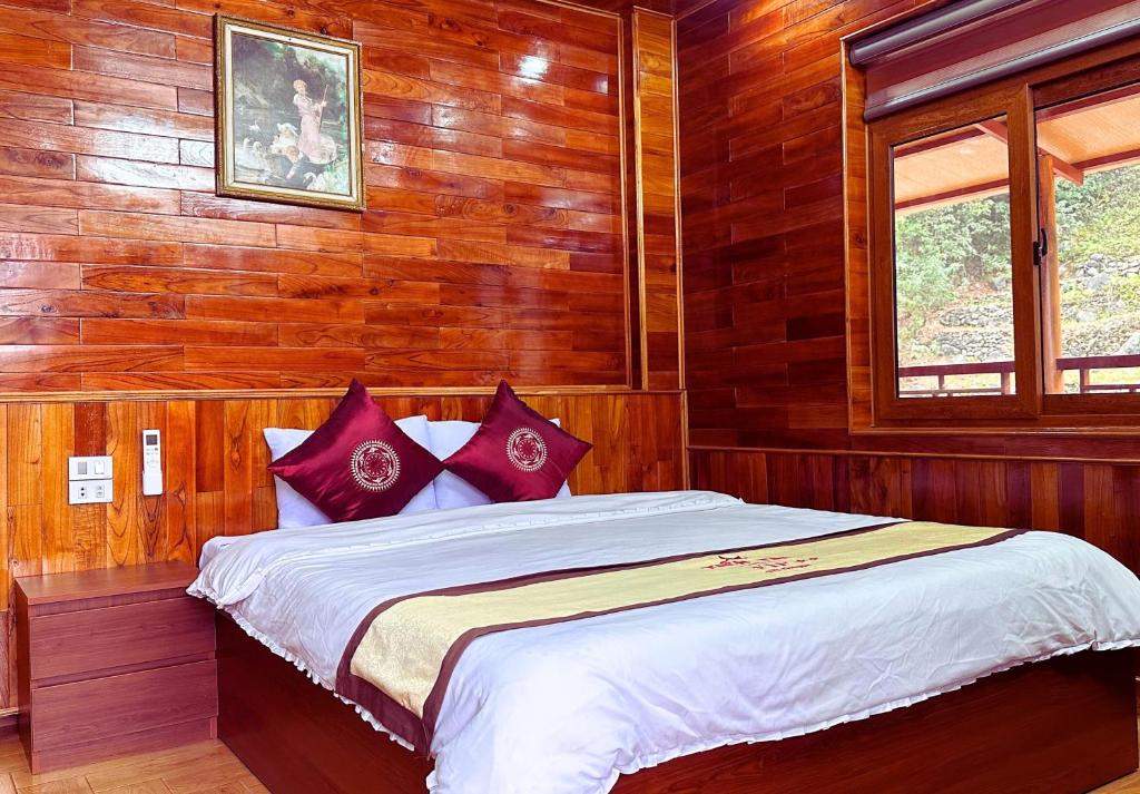 Mèo VạcTIEN TAI HOTEL 1的木制客房内的一间卧室配有一张大床