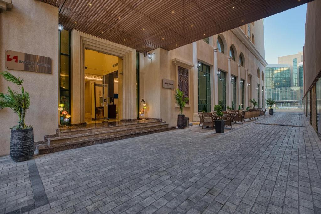 多哈Swiss-Belinn Doha的建筑里一条空的走道,上面有植物