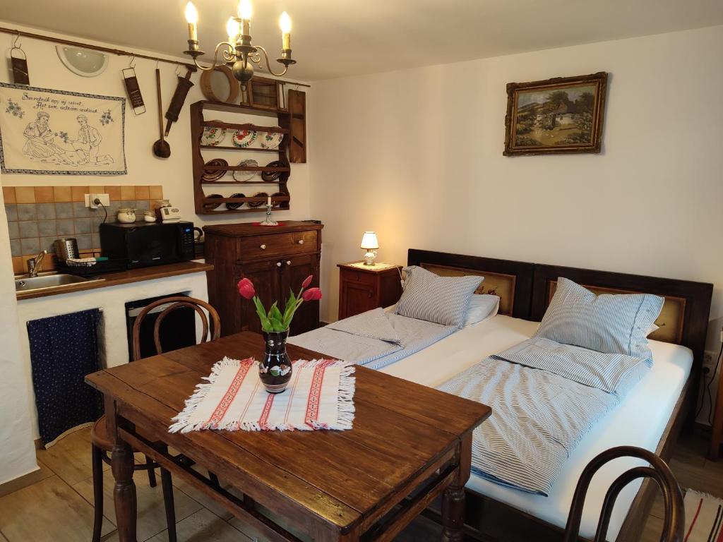 塔塔Szent Iván Vendégház的一间卧室配有一张床和一张鲜花桌子