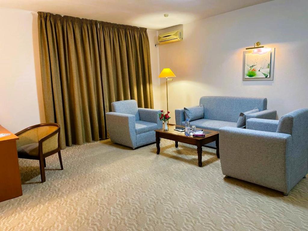 阿特劳腾格里酒店的客厅配有两把椅子、一张沙发和一张桌子