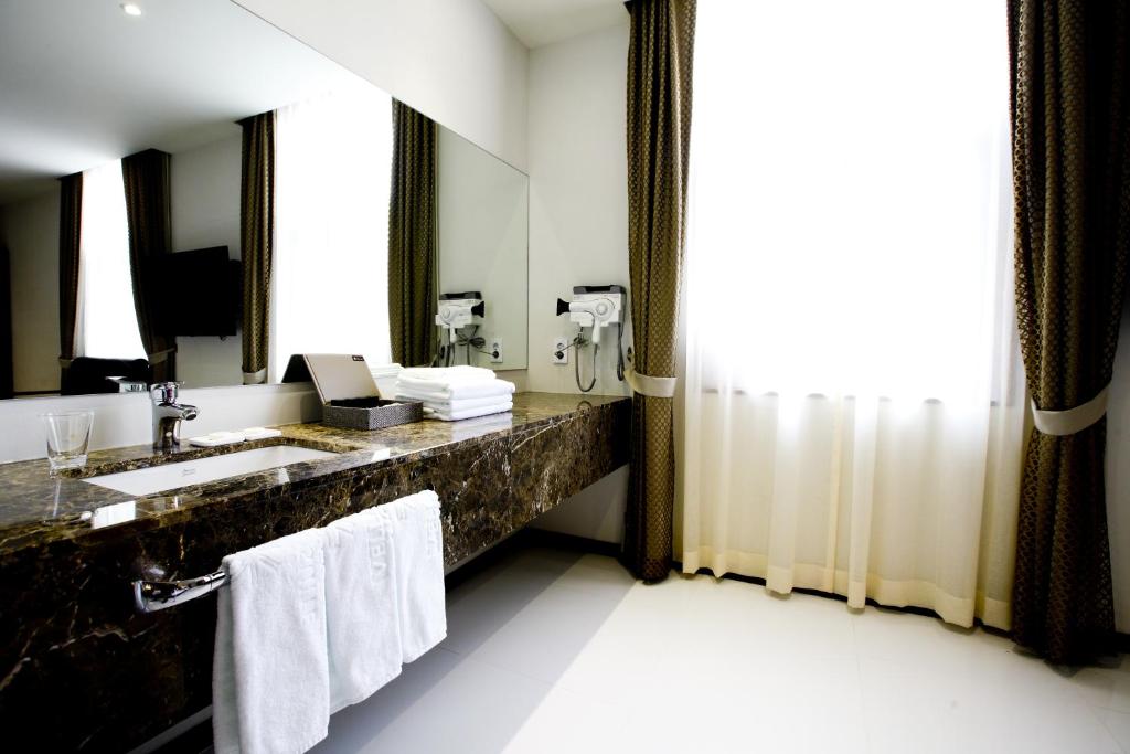 首尔明洞多玛酒店的一间带水槽和镜子的浴室