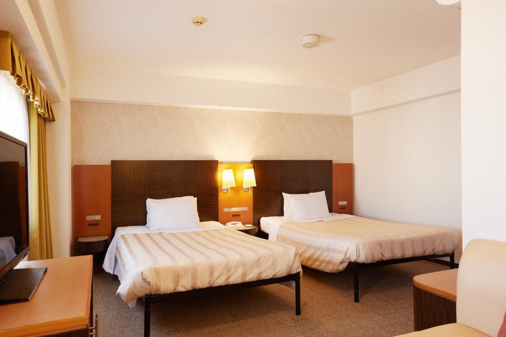 那霸GRG那霸东町酒店的酒店客房配有两张床和一张书桌