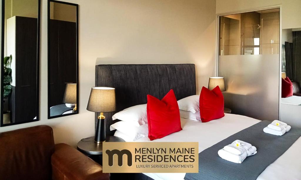 比勒陀利亚Menlyn Maine Residences - Paris king sized bed的配有红色枕头的床的酒店客房