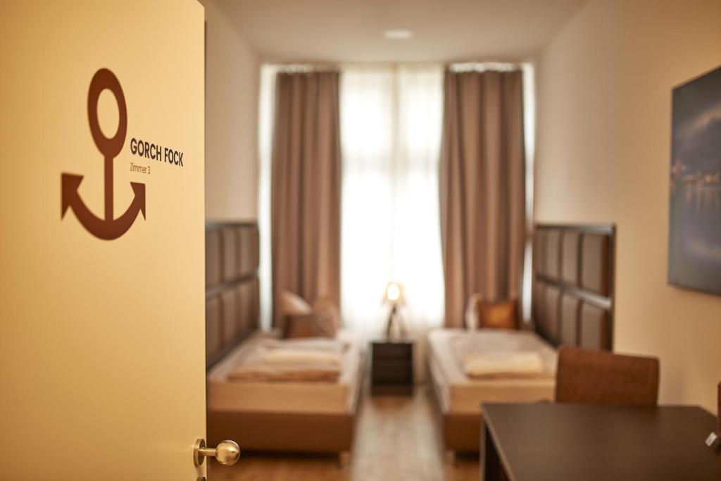卡尔斯鲁厄Harbour Apartments的一间带两张床的房间和一间带桌子的客厅