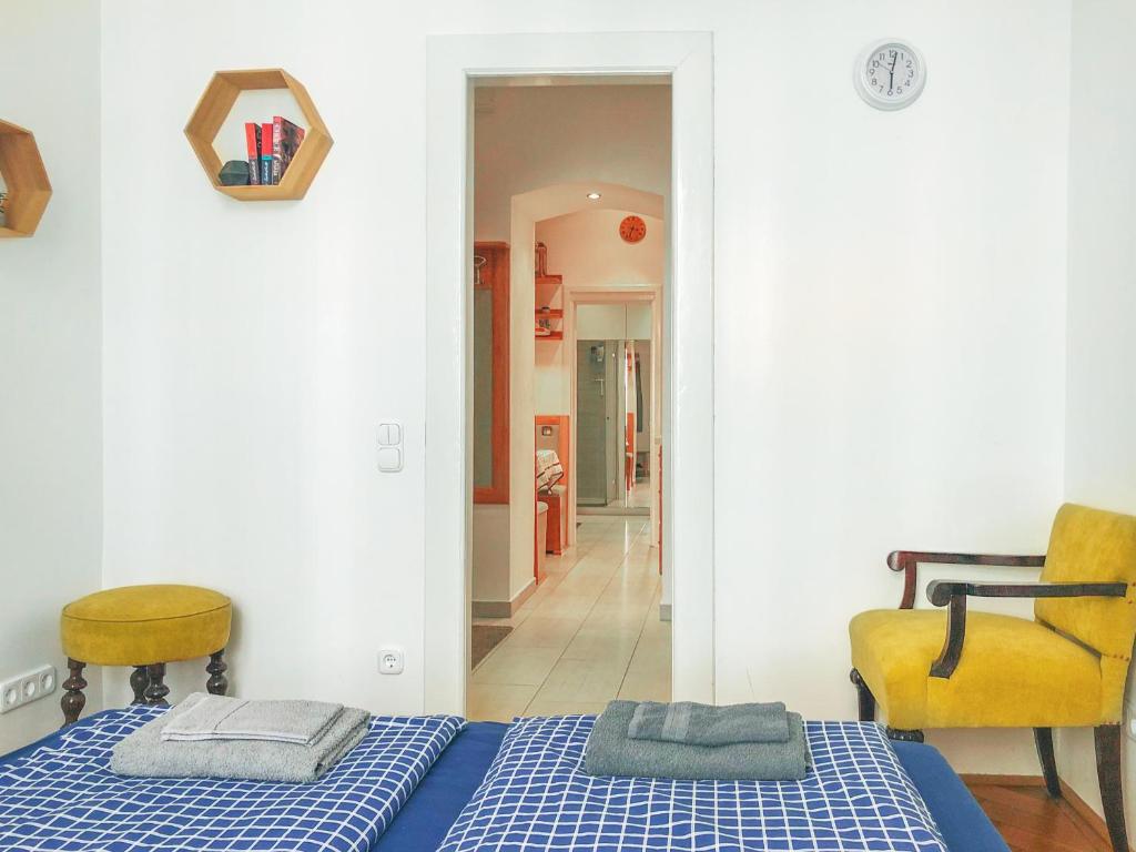 布达佩斯Historic Old Town Home的一间卧室配有蓝色的床和黄色的椅子