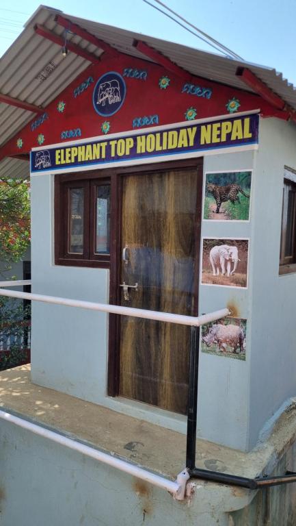 TānsenElephant Top Holiday Nepal, Homestay, Tansen的上面有顶级假日夜 ⁇ 标志的建筑