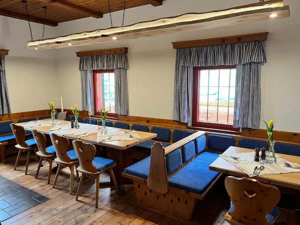 BaldramsdorfLandgasthof Marhube的用餐室配有木桌和蓝色椅子