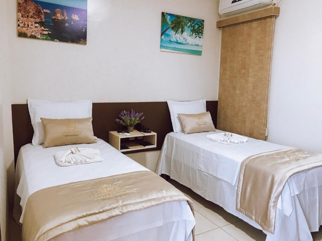 Barra do CordaHOTEL VIANA的配有白色床单的客房内的两张床