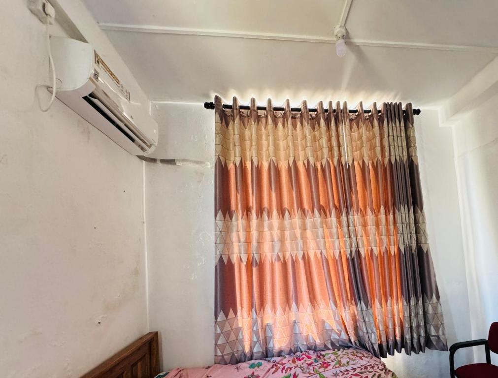 亭可马里Ravan Holiday Inn的一间小房间带窗帘的卧室