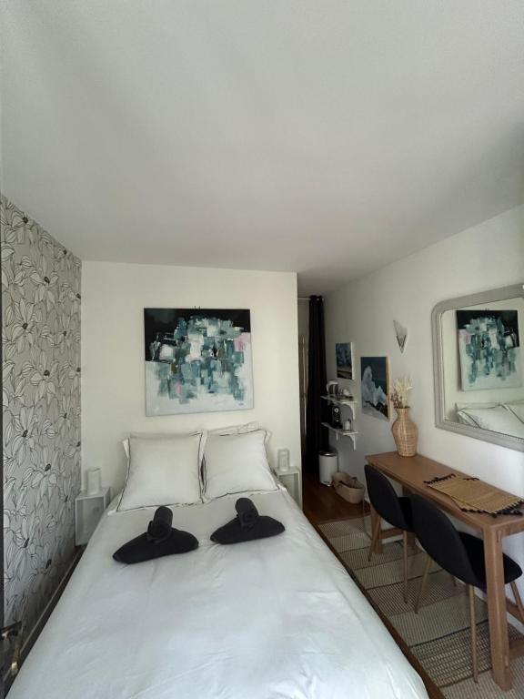 圣莫代福塞Chambre d hôte - Bambou的一间卧室,配有一张带两顶帽子的床