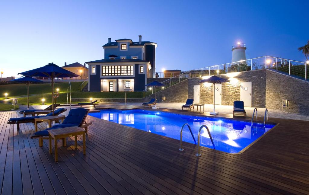 拉卡里达Apartamentos Viavelez的一座带椅子的甲板上的游泳池和一座建筑