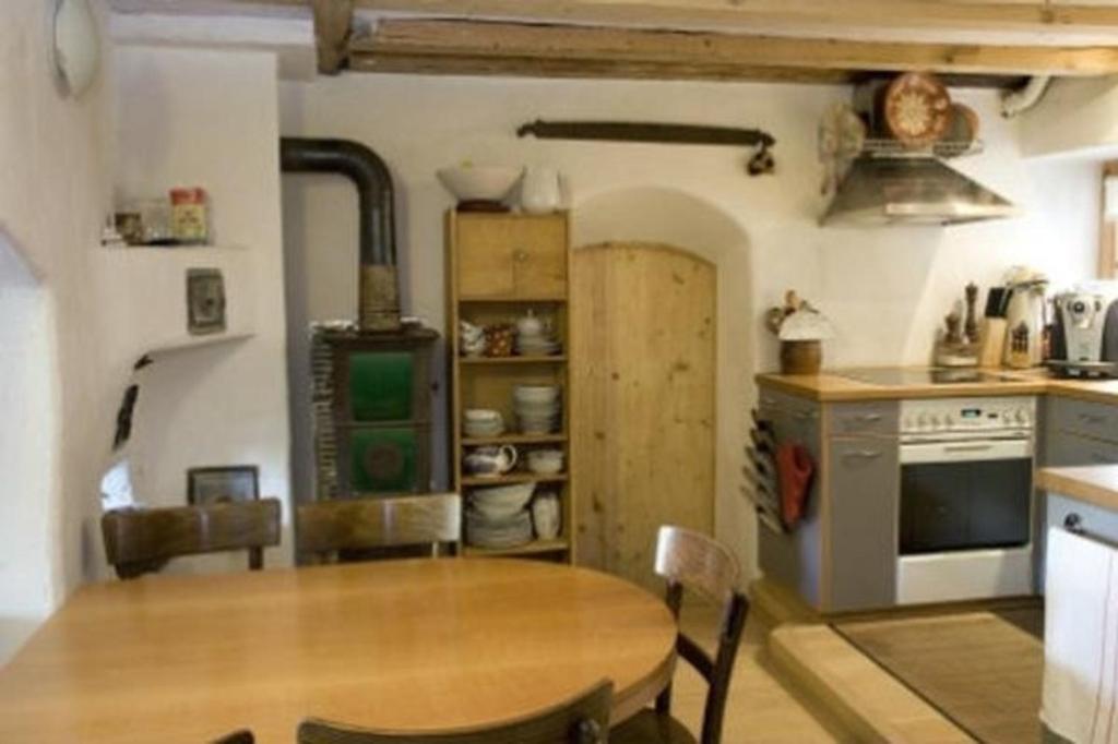 迈恩费尔德Das spezielle Ferienhaus Heidi - b48536的厨房配有木桌和炉灶。