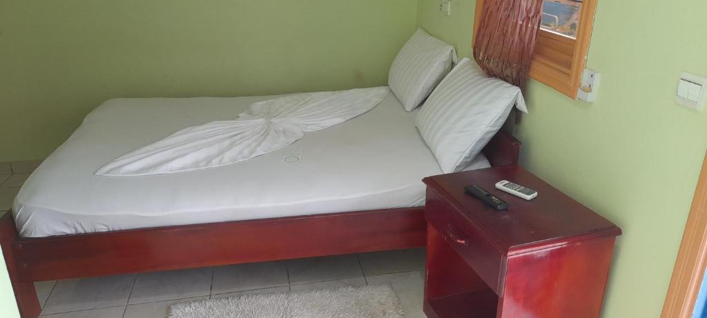 弗朗斯维尔CHEZLIBAMA的一张小床,配有白色床单和桌子旁的枕头