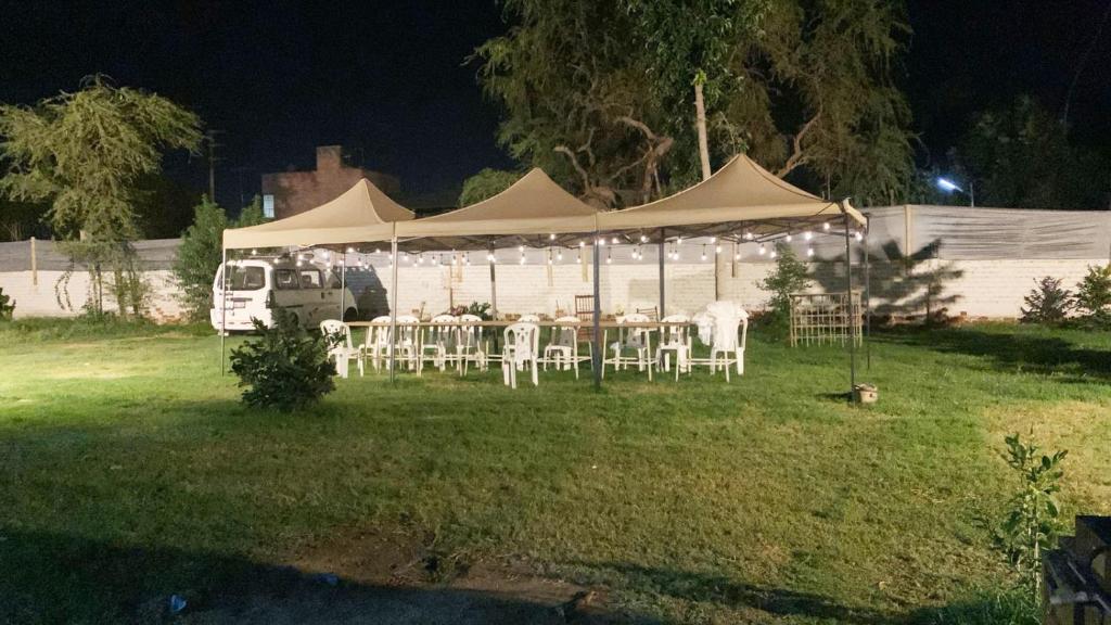 伊察Casa de Campo - Fundo Raquel的夜晚在院子里带桌椅的帐篷