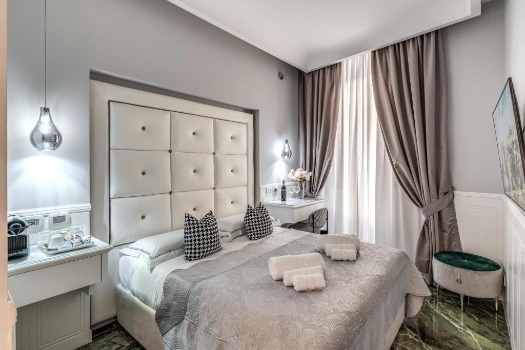 罗马罗马55号旅馆 - 西班牙广场的一间卧室配有一张大床和两把椅子