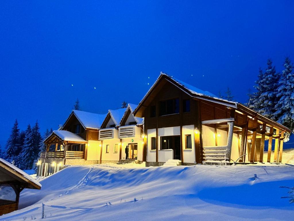 贝利什Tiarra Mountain Lodge的夜晚雪中的房子