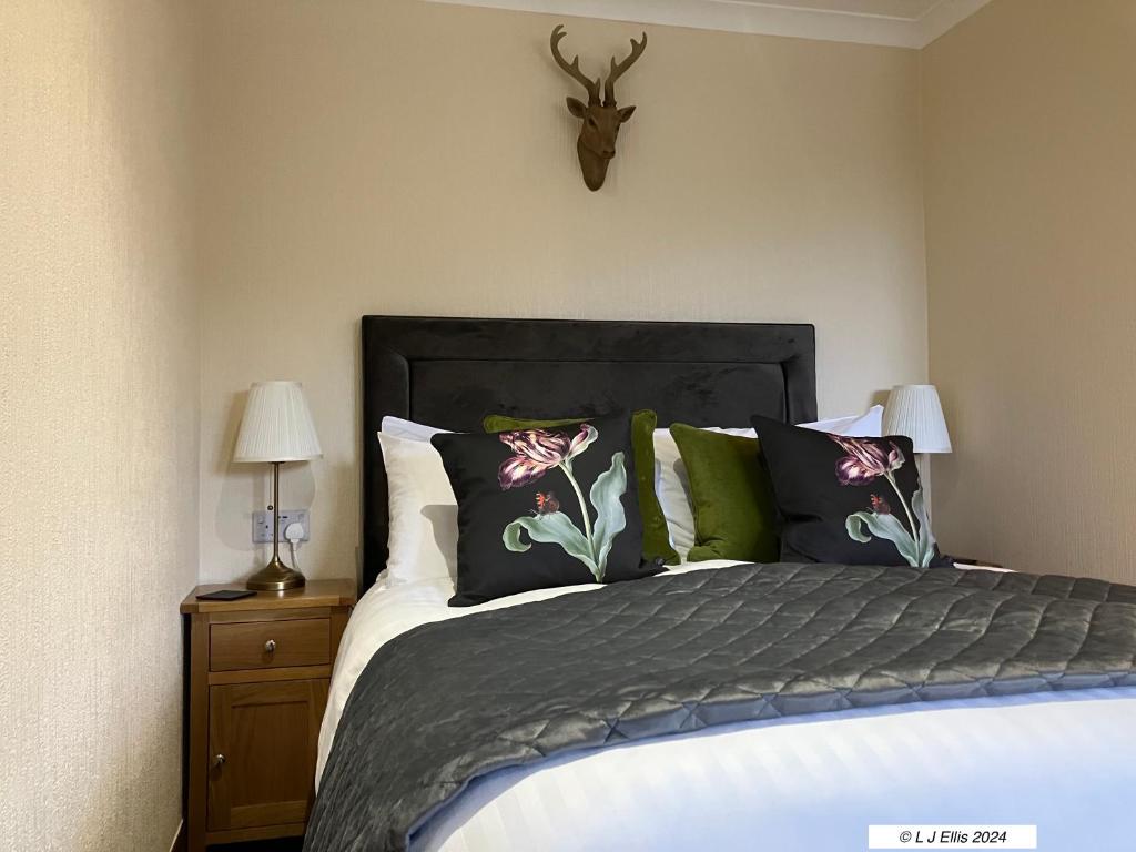 福耶斯佛雅尔斯酒店的卧室配有带枕头的床和墙上的鹿头