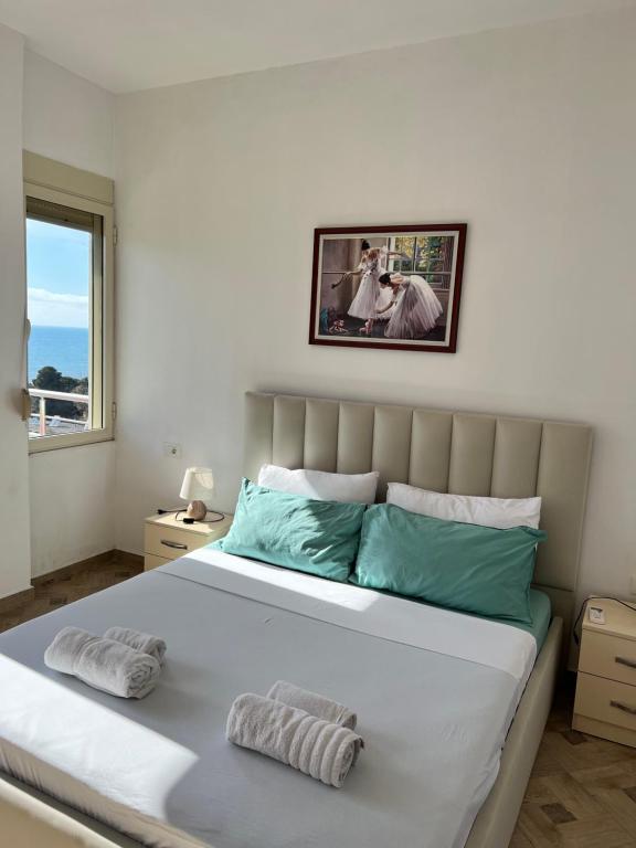 都拉斯LunaSol seaside Apartments的一间卧室配有一张大床和两个枕头