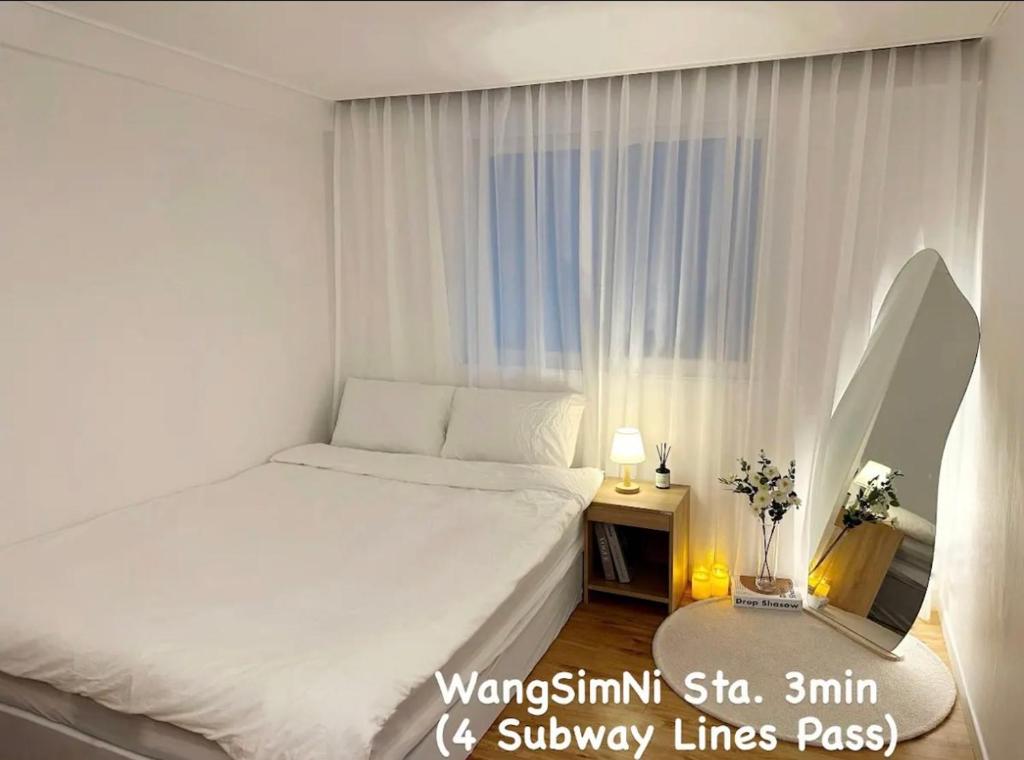 首尔Han Stay的窗户客房内的一张白色床