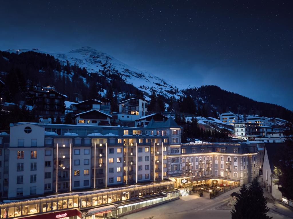 达沃斯Precise Tale Seehof Davos的夜晚的酒店,以山为背景