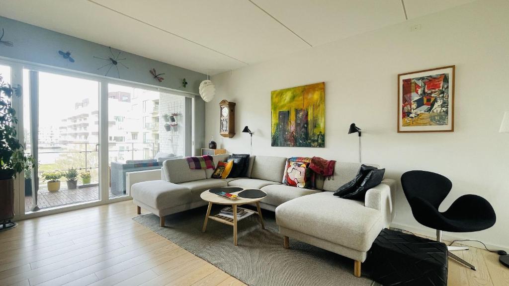 哥本哈根ApartmentInCopenhagen Apartment 1601的客厅配有沙发和两把椅子