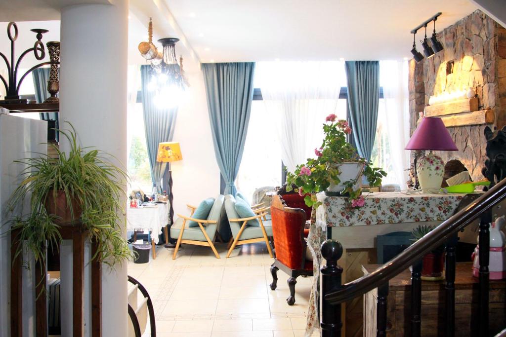 丽江La Maison du Laoshay Lijiang的客厅配有蓝色窗帘和桌子