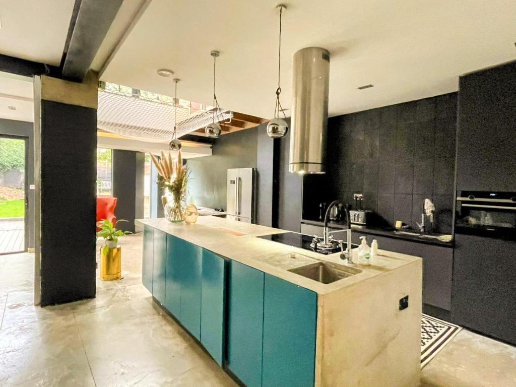 伦敦Remarkable 7-Bed House in London的厨房配有蓝色橱柜和水槽