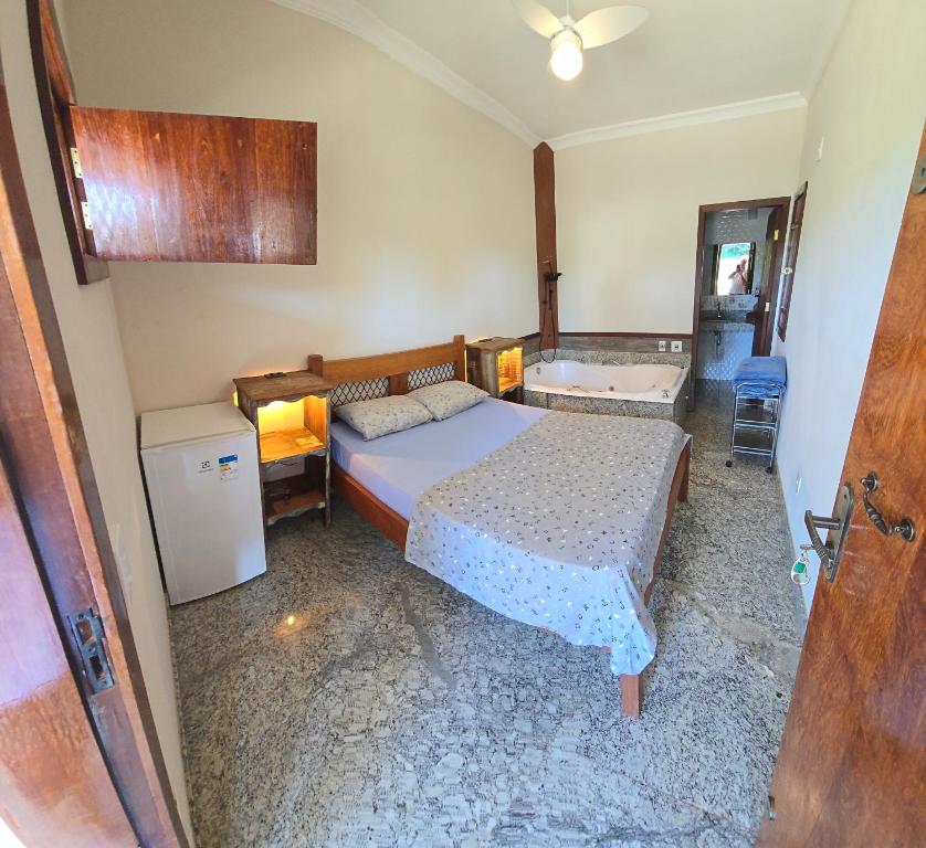 CaratingaFazenda do Prata Ecoresort的一间卧室配有一张床和一个浴缸