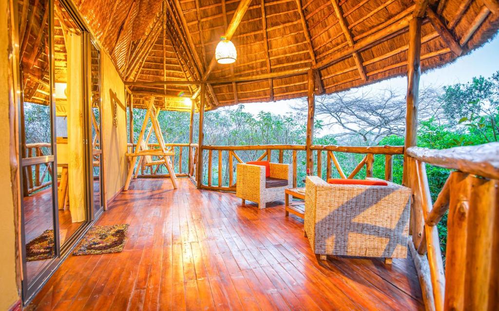 KatokeEmbogo Safari Lodges的一座铺有木地板的房屋的门廊