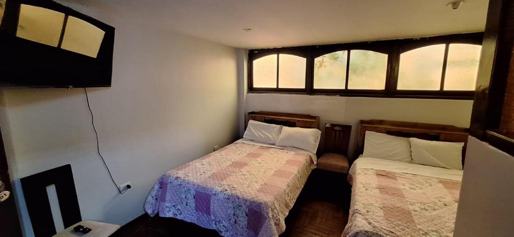卡哈马卡La casa de Mary的一间带两张床和电视的小卧室