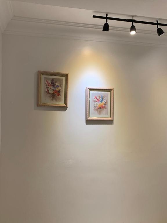 丹吉尔cozy appartement meublé的两幅画作,画在白色的墙上,有灯光