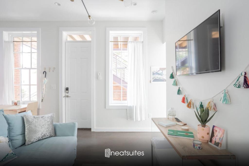 卡温顿Pastel Paradise - Adorable Covington Apartment的客厅配有蓝色的沙发和电视