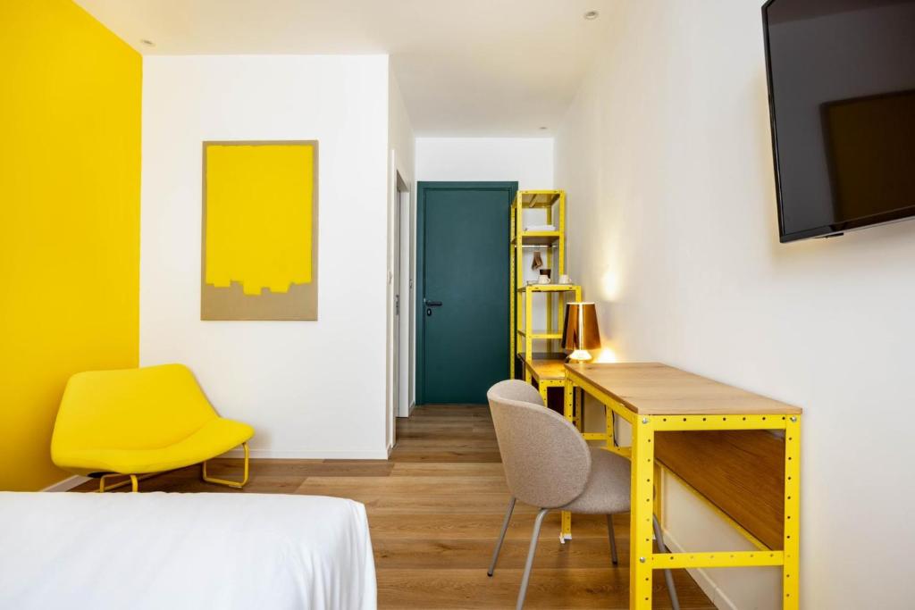 Giv‘atayimSirkin 16 Hotel - Autonomous hotel的一间卧室配有黄色的办公桌和黄色的椅子