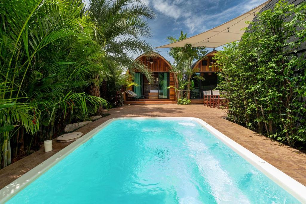 Ban Pak LakNew 3BR Chalet-Style Villa Pasak Paradise 3, Private Pool, 10min grive to Laguna Phuket的一座树木繁茂的房屋前的游泳池