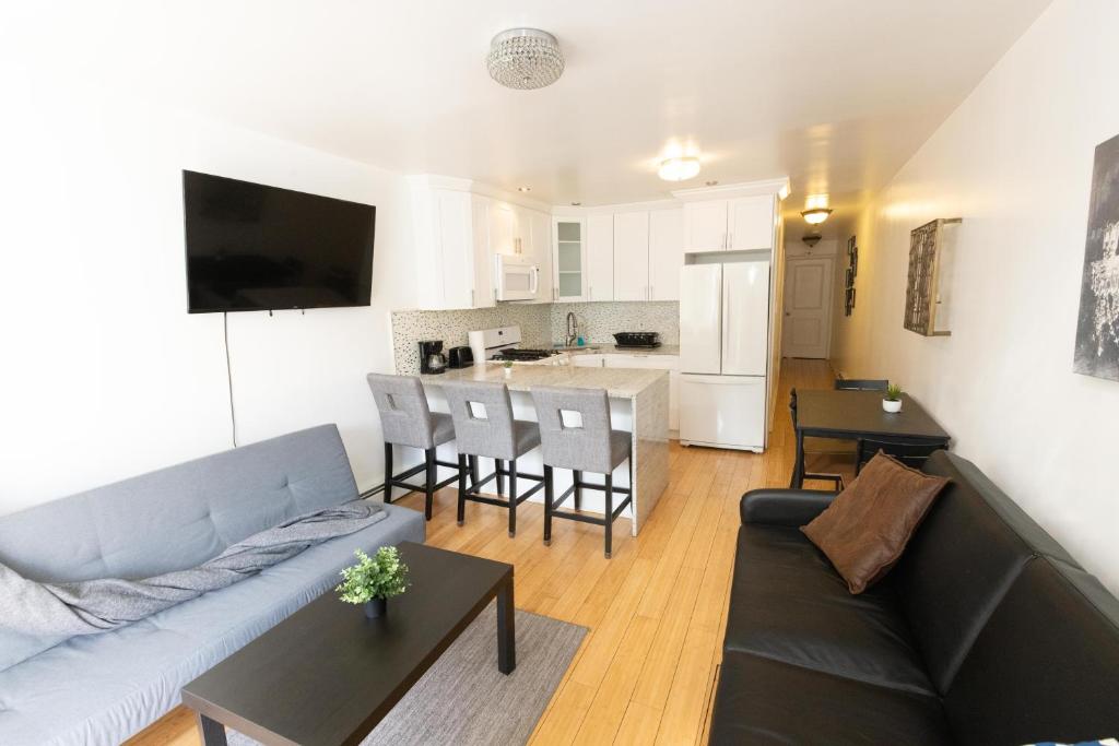 联城Convenient and private 2bed home mins to NYC的带沙发和桌子的客厅以及厨房。