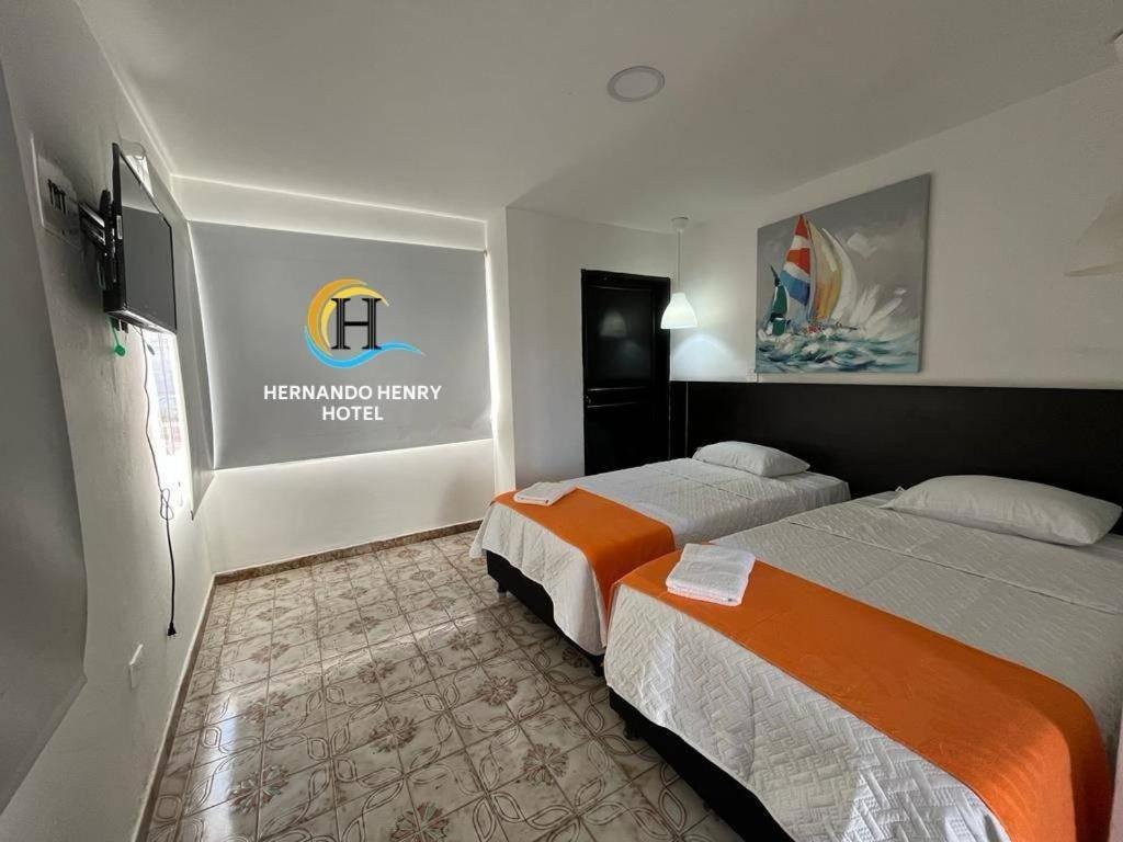 圣安德烈斯HOTEL HERNANDO HENRY的酒店客房设有两张床,墙上有标志