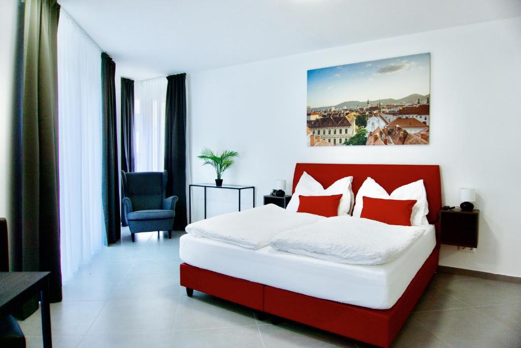 格拉茨Grazora Living Apartments的卧室配有红色和白色的床和椅子